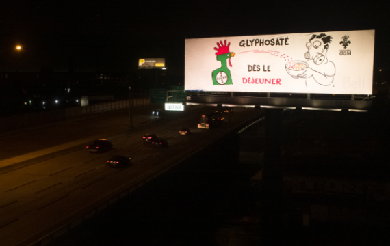 Bannière sur l'échangeur turcot avec un aspergeur è pestcides en forme de coq aspergeant un bol de céréal d'un monsieur avec un masque à gas avec le slogan: Glyphosaté dès le déjeuner