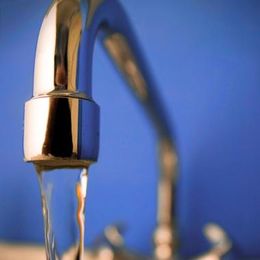 robinet avec de l'eau qui coule sur fond bleu